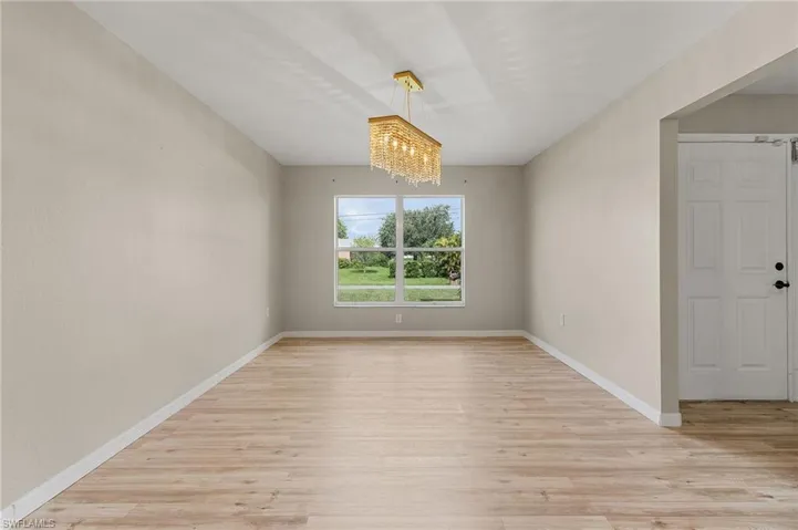 Formal dining room with vinyl flooring and chandelier