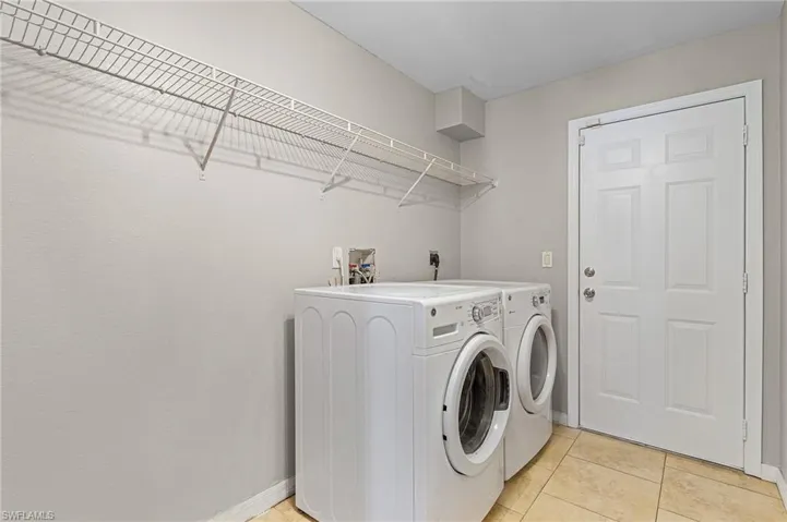Laundry room with light tile flooring, separate washer and dryer, washer hookup, and electric dryer hookup