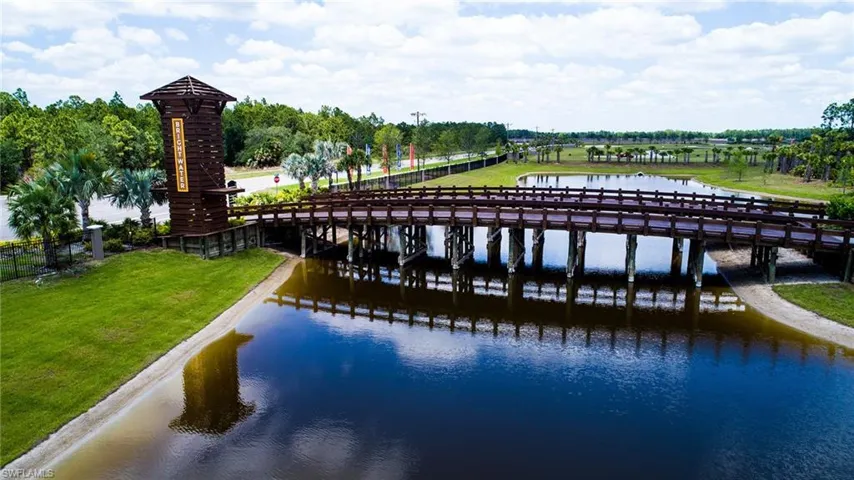 Dock featuring a lawn, a water view, and view of wooded area