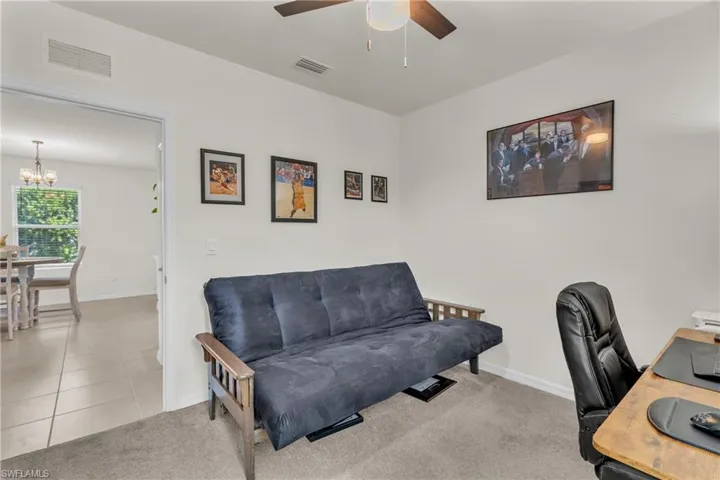 Office with light carpet, a ceiling fan, a chandelier, and light tile patterned flooring