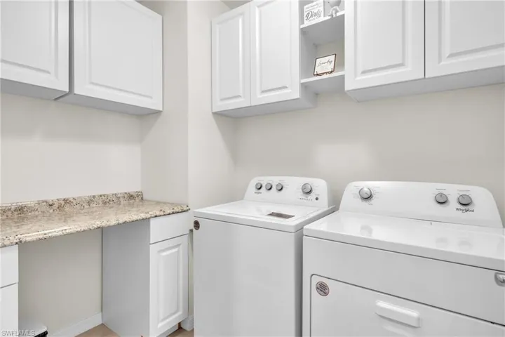 Washroom featuring washing machine and dryer and cabinet space