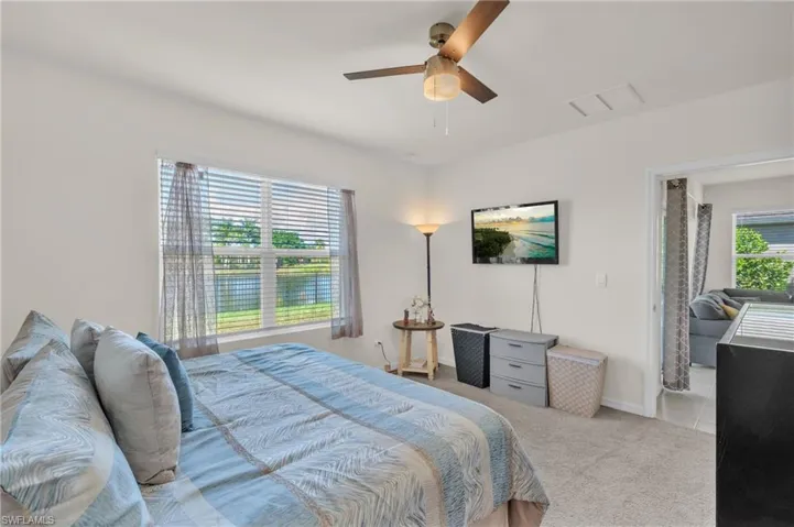 Carpeted bedroom with ceiling fan and baseboards