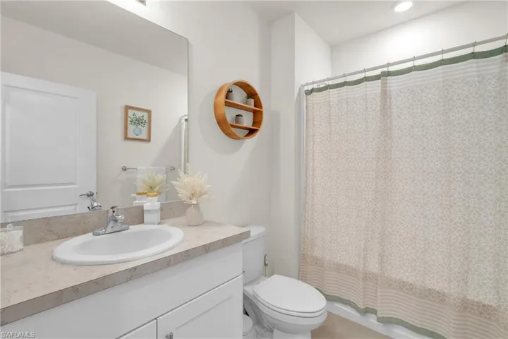 Bathroom featuring vanity and shower / bath combination with curtain