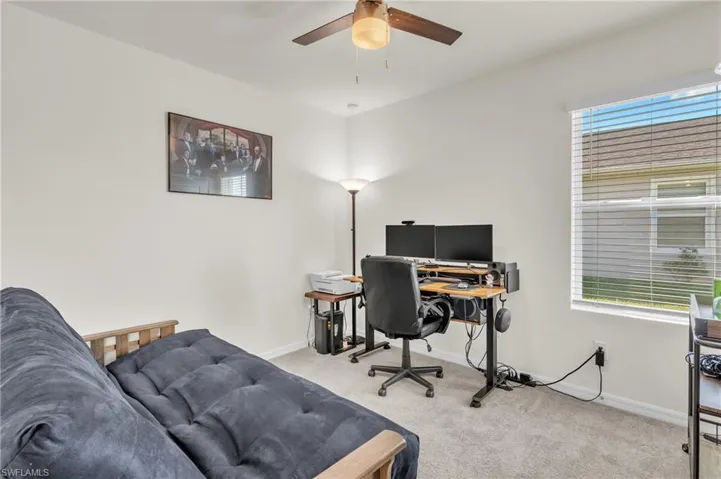 Office space featuring light colored carpet and a ceiling fan