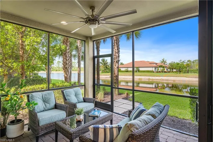 Sunroom / solarium featuring ceiling fan and a water view