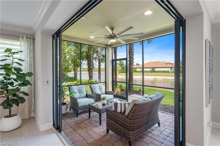 Sunroom / solarium featuring plenty of natural light, ceiling fan, and a water view