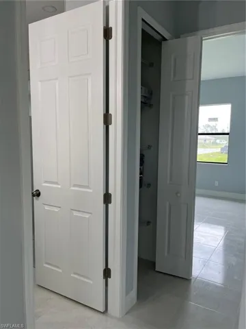 Hallway with light tile patterned floors