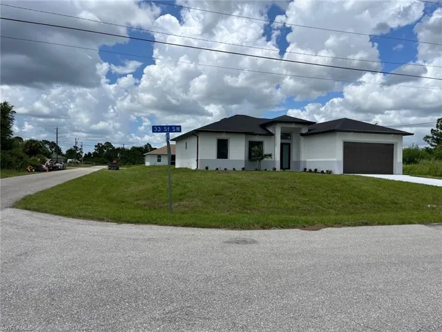 View of front of house with a garage and a front lawn