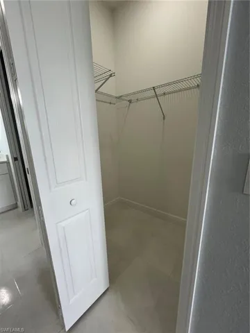 Walk in closet with light tile patterned floors