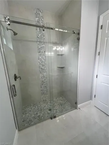 Bathroom featuring walk in shower and tile patterned floors
