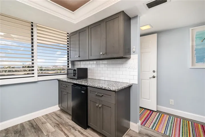 ADDITIONAL CABINETRY W/GRANITE COUNTERTOP AND BUILT-IN FREEZER.  FULL-HEIGHT SUBWAY TILED BACKSPLASH.  PLANTATION SHUTTERS.