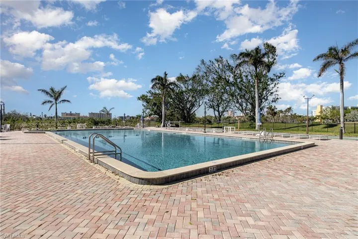 VIEW OF PAVERED COMMUNITY POOL AND SHUFFLEBOARD COURTS