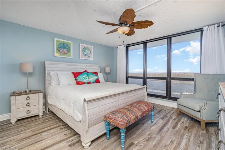 SPACIOUS OWNER'S SUITE HAS A NEARLY FULL WALL OF IMPACT RESISTANT WINDOWS WITH DIRECT ESTERO BAY VIEWS.  EN-SUITE IS TO LEFT.