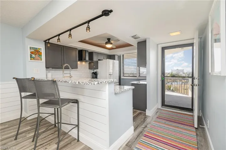 BREAKFAST BAR WITH SHIPLAP FRONT. SHIPLAP WAINSCOTING IN DINING AND LIVING AREA.  TRACK LIGHTING.   UNIT ENTRANCE SHOWN.