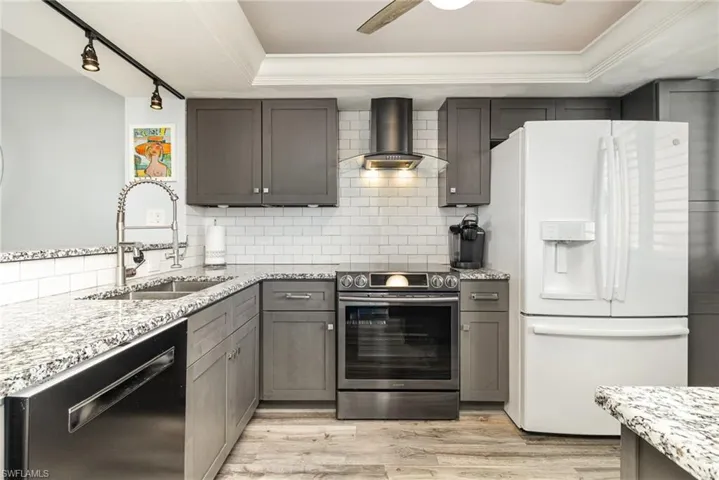 BEAUTIFULLY UPDATED KITCHEN.  CABINETS.  GRANITE COUNTERTOPS.  UNDER-MOUNT STAINLESSFULL-HEIGHT SUBWAY TILE BACKSPLASH.  MODERN HOOD W/LIGHTING.