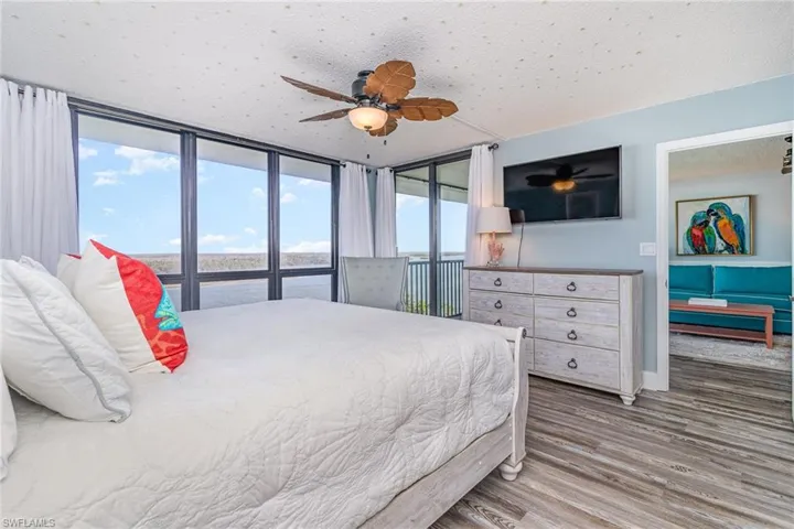OWNER'S SUITE SHOWING DIRECT ENTRANCE TO LANAI AND ENTRANCE TO MAIN LIVING AREA.  WALL-MOUNTED FLAT SCREEN TV.  KING BED.