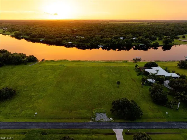 Aerial view at dusk featuring a rural view and a water view