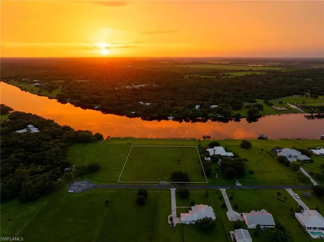 Aerial view at dusk featuring a water view