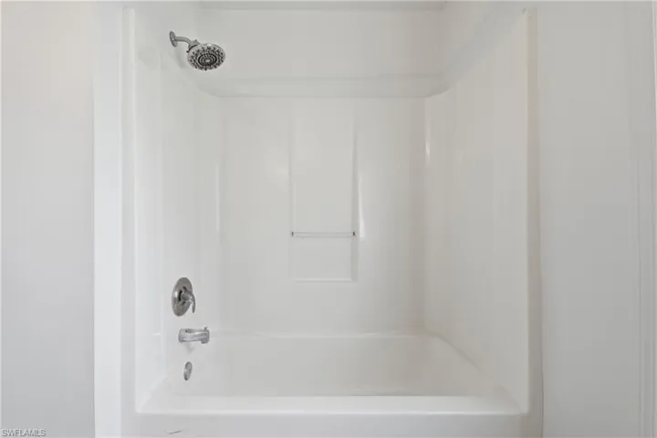 White tub and shower combination with chrome fixtures