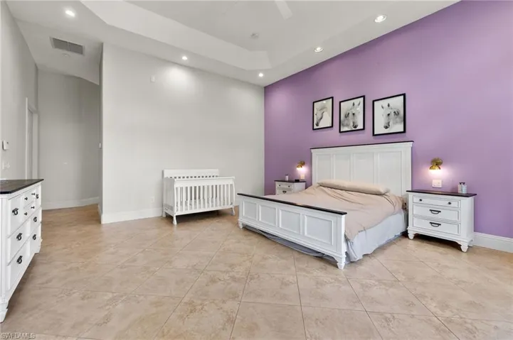 Bedroom featuring ceiling fan, a high ceiling, and light tile patterned flooring
