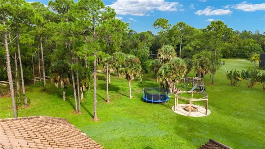View of home's community featuring a yard and a trampoline