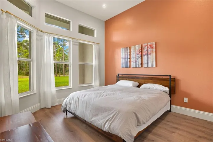 Bedroom with multiple windows and hardwood / wood-style flooring