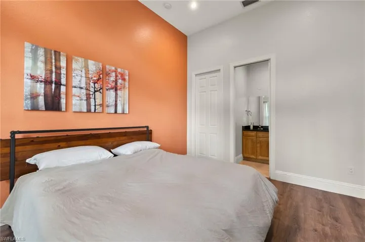Bedroom featuring connected bathroom and dark hardwood / wood-style floors