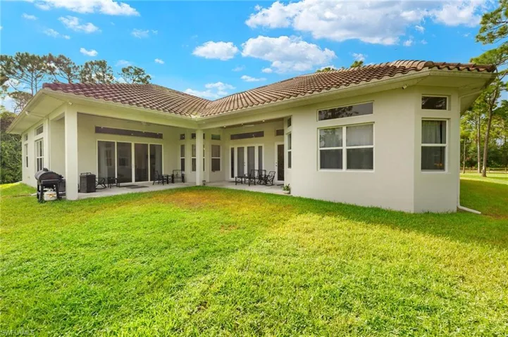 Back of property with a yard and a patio area