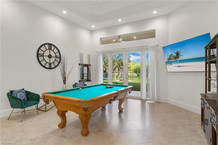 Game room featuring french doors, light tile patterned floors, a high ceiling, and pool table