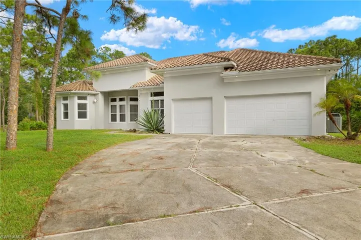Mediterranean / spanish home with a front yard and a garage