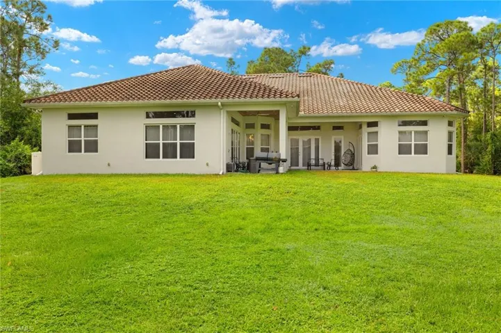 Rear view of house featuring a yard and a patio