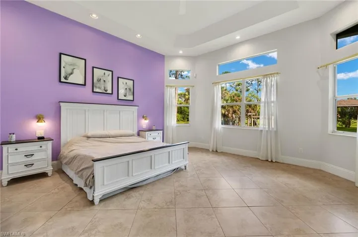 Tiled bedroom with ceiling fan and multiple windows