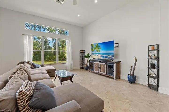 Tiled living room with high vaulted ceiling