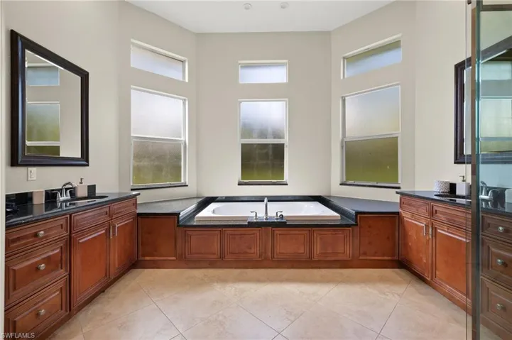 Bathroom with a tub, tile patterned flooring, and vanity