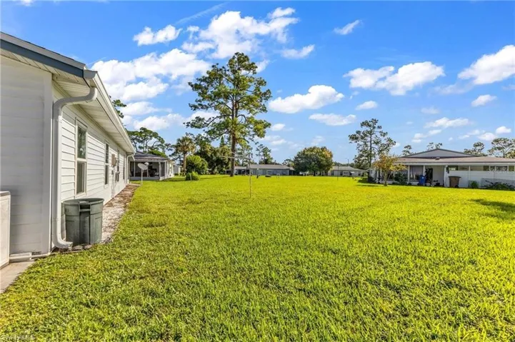 Expansive green space featuring a large grassy area and distant residential structures