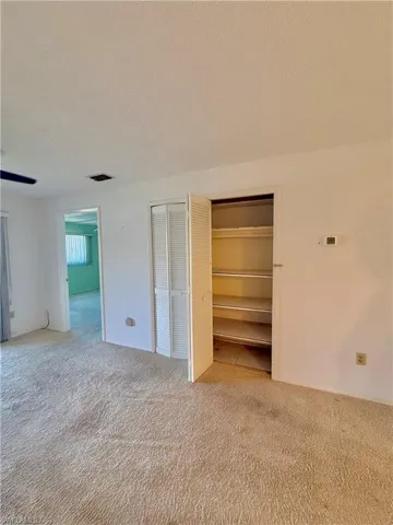 Unfurnished bedroom featuring a textured ceiling and light colored carpet