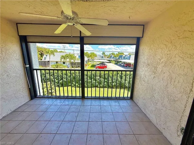 Unfurnished sunroom with ceiling fan, healthy amount of natural light, and a balcony