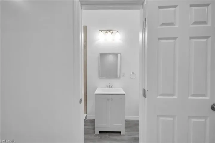 Bathroom with vanity, wood finished floors, and a shower
