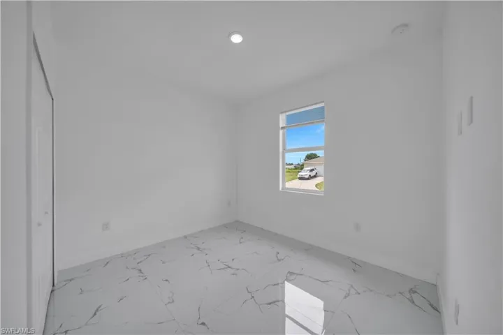 Unfurnished room with light marble finish flooring and recessed lighting