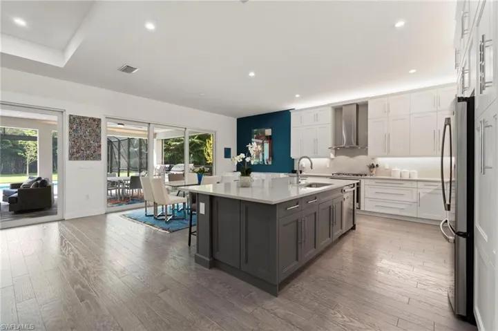 Top-of-the-line kitchen features include a vented range hood, built-in pantry, added row of top cabinets, quartz counter and backsplash, under and over cabinet lighting.