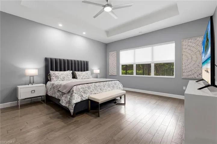 Inviting primary suite with sitting area, electric window treatments.