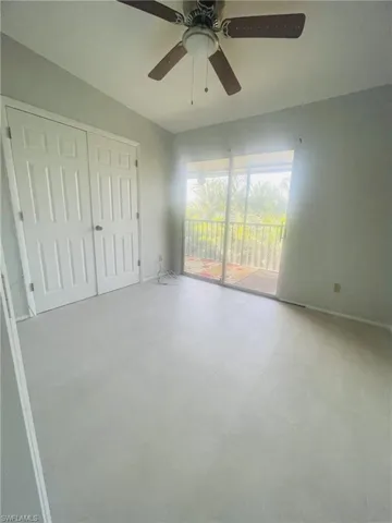 Unfurnished bedroom featuring access to exterior, a closet, and ceiling fan