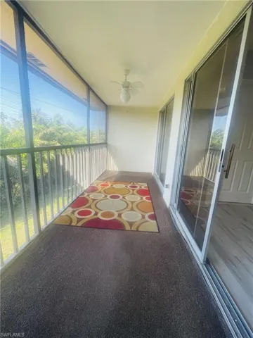 Sunroom / solarium featuring a balcony, ceiling fan, and plenty of natural light