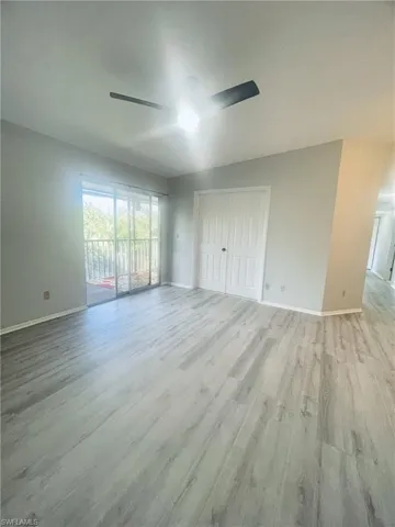 Unfurnished bedroom featuring a closet, light wood-style floors, access to outside, and ceiling fan