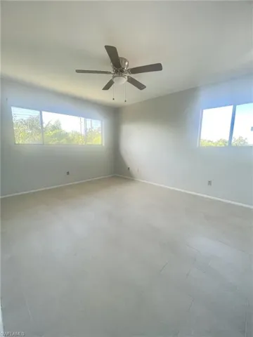 Empty room with plenty of natural light and a ceiling fan