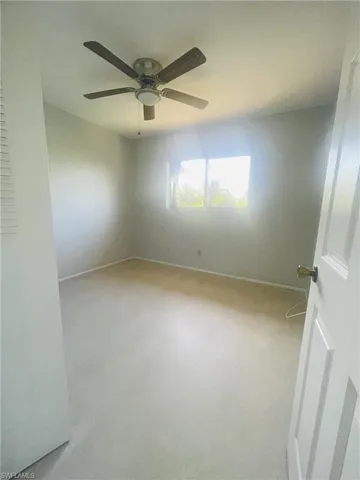 Empty room featuring a ceiling fan and light flooring