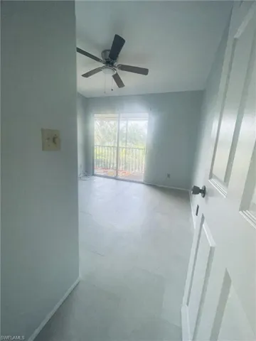 Unfurnished room with ceiling fan and baseboards