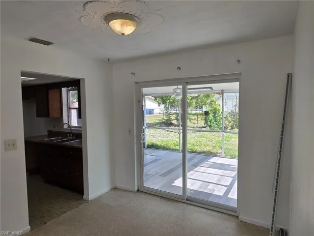 Sliding glass doors opening to an outdoor patio with tiled flooring