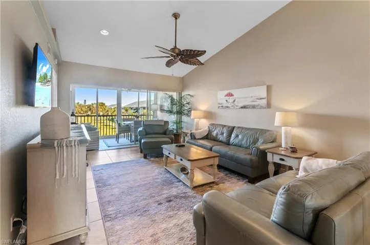 Tiled living room featuring high vaulted ceiling and ceiling fan