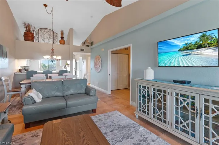 Tiled living room with lofted ceiling and an inviting chandelier